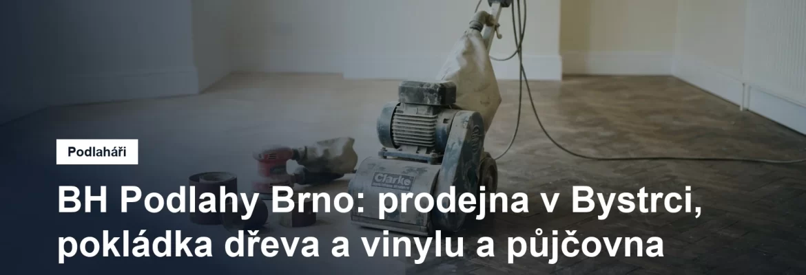 Válcová bruska na parkety uprostřed rozbroušené dubové podlahy, vedle ní role brusného papíru a okrajová bruska