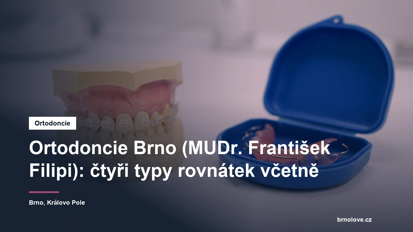Detail modelu chrupu s fixním aparátem s průhlednými zámky, vedle na stolku snímací aparát v pouzdře
