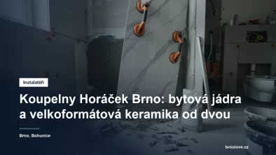 Obkladač pokládá velkoformátovou keramickou desku na stěnu koupelny během rekonstrukce