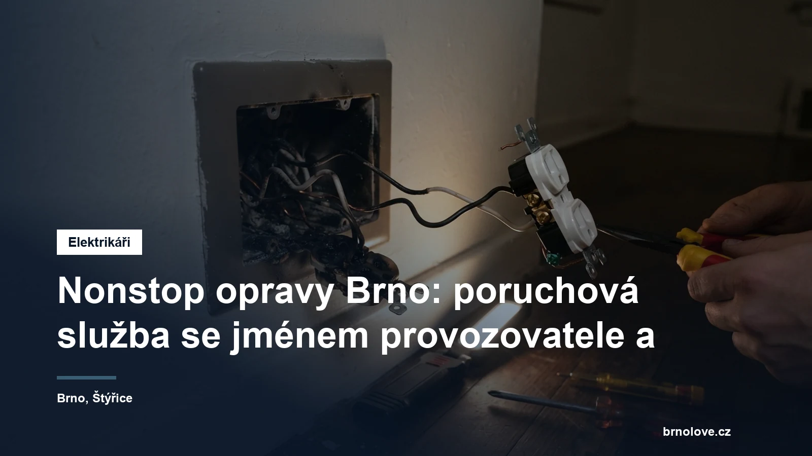 Elektrikář vyměňuje vyhořelou zásuvku ve zdi bytu, na místě má nářadí a přenosné pracovní světlo