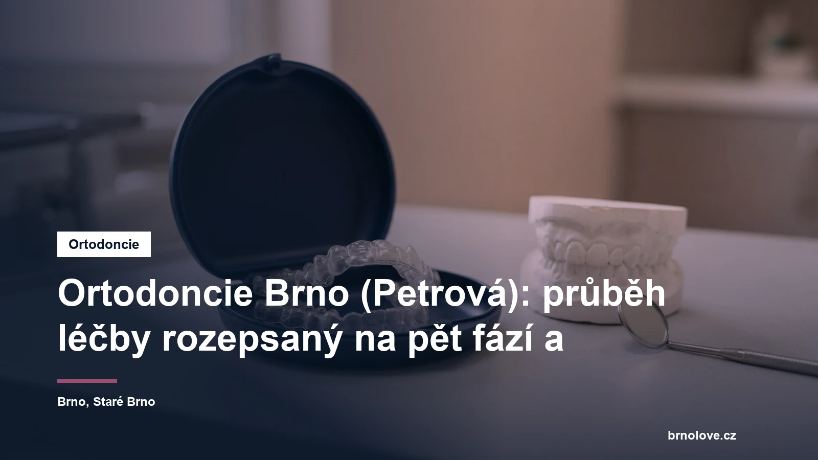 Průhledná fóliová rovnátka v otevřeném pouzdře na stolku ordinace, vedle model chrupu a zrcátko
