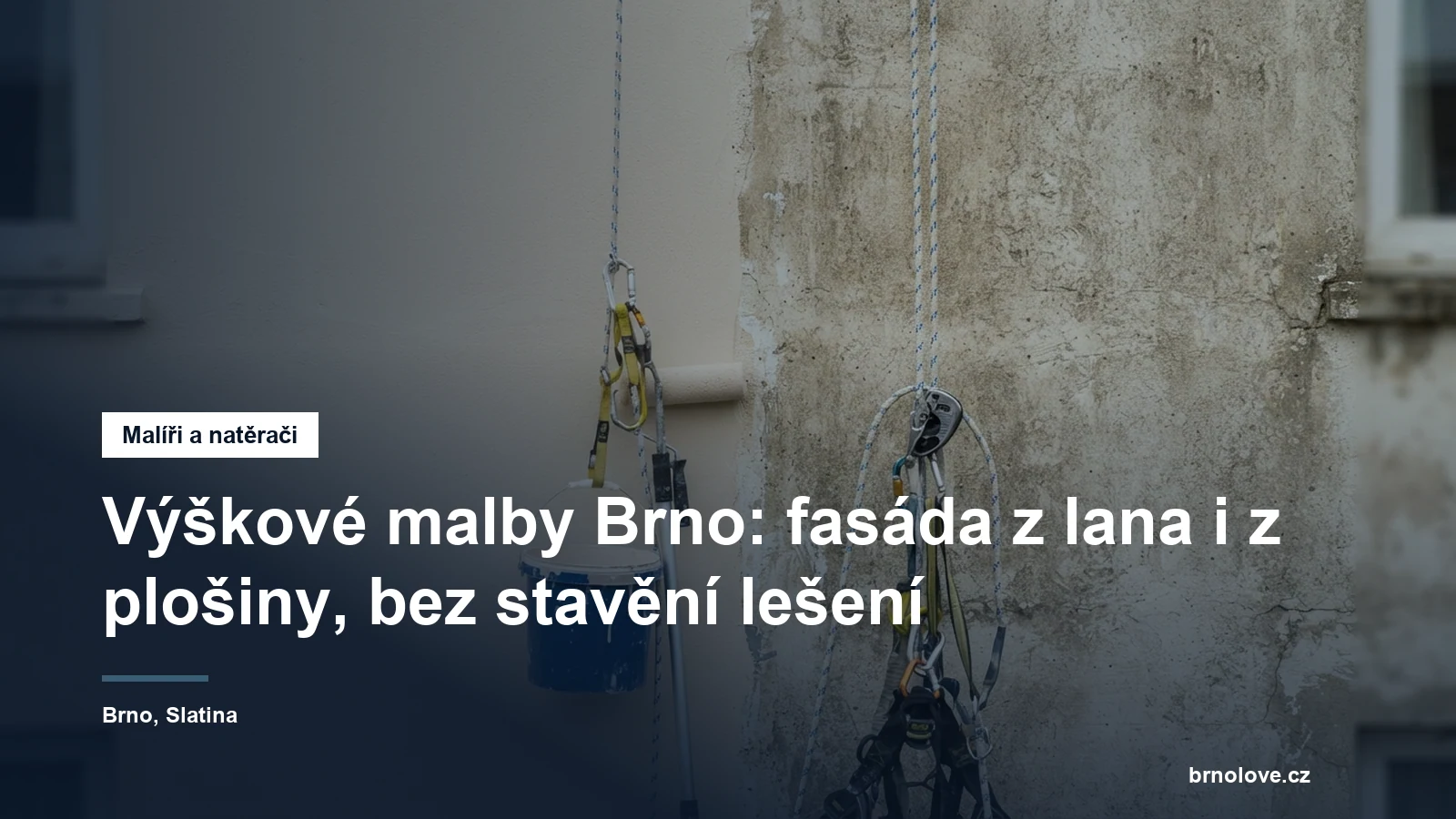 Nátěr fasády panelového domu z lanového přístupu, na stěně visí pracovní lana s brzdou a vedle nich kbelík s barvou a váleček na teleskopické tyči