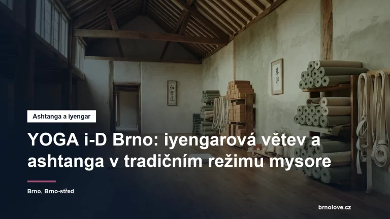 Jógový sál s vysokým stropem, podložkami a pomůckami u zdi, bez lidí