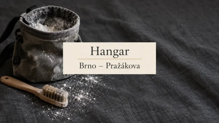 Lezecký sáček a kartáček na šedé textilii, titulek Hangar – Brno-Pražákova