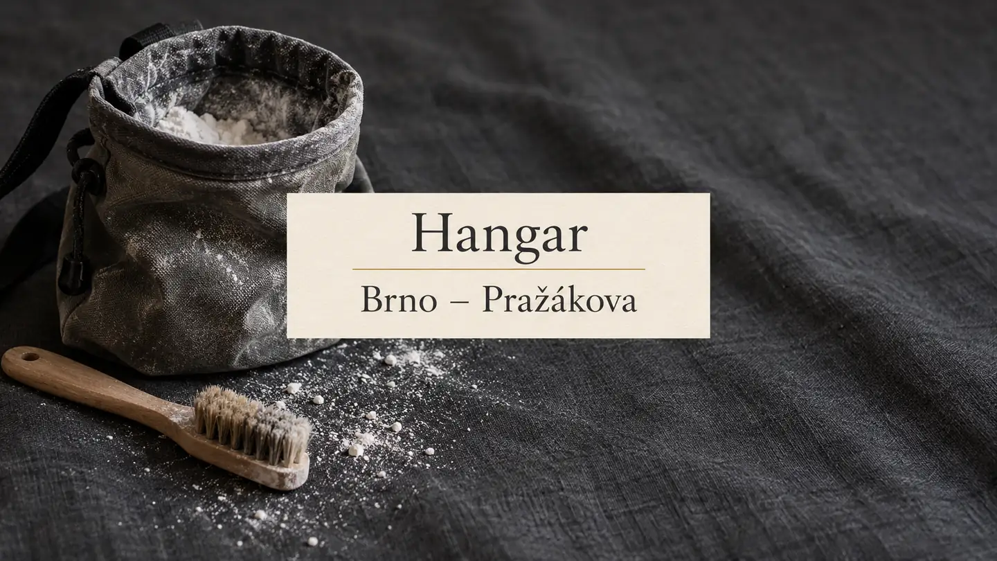 Lezecký sáček a kartáček na šedé textilii, titulek Hangar – Brno-Pražákova