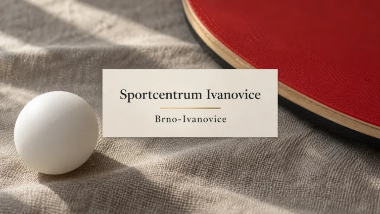 Míček na stolní tenis a okraj červené pálky na látce, titulek Sportcentrum Ivanovice – Brno-Ivanovice